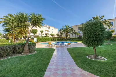 a courtyard with tables and chairs and palm trees at Lagos beach condo in Lagos