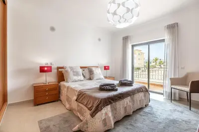 a bedroom with a bed and a large window at Lagos beach condo in Lagos