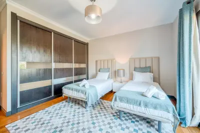 a bedroom with two beds and a large window at Villa Vacuna by Amazing Madeira in Funchal