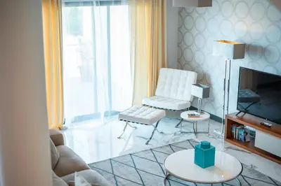a living room with a white chair and a television at Villa Vacuna by Amazing Madeira in Funchal