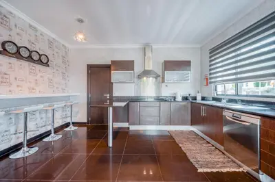 a kitchen with wooden cabinets and stainless steel appliances at Villa Vacuna by Amazing Madeira in Funchal