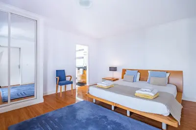 a bedroom with a large bed and a blue rug at Vila Crerital - By Wehost in São Gonçalo