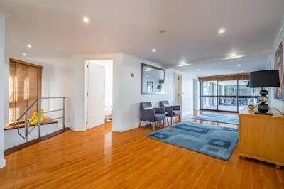 an open living room with wooden floors and white walls at Vila Crerital - By Wehost in São Gonçalo