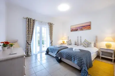 a bedroom with a bed and a table and a window at Casa Ensolarada in Budens