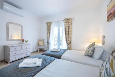 a bedroom with two beds and a mirror and a dresser at Casa Ensolarada in Budens