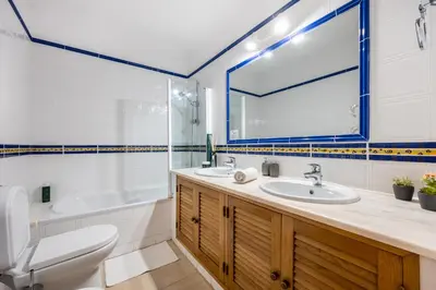 a bathroom with a sink and a tub and a toilet at Casa Ensolarada in Budens