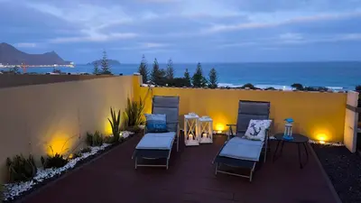 a white table in a room with a table and a couch at Thelighthouse Porto Santo in Porto Santo