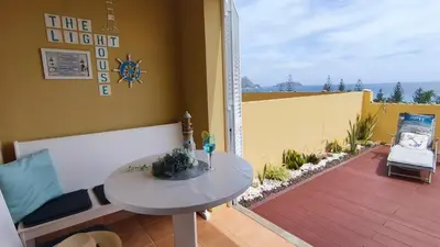a room with a white table and a glass door at Thelighthouse Porto Santo in Porto Santo