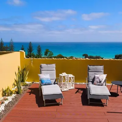 a chair with a colorful blanket sitting on a patio at Thelighthouse Porto Santo in Porto Santo