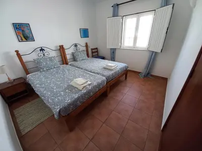 a small bedroom with a bed and a window at Cool Villas T1 in Sagres