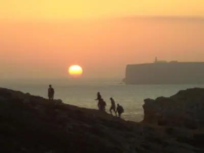 a group of people walking on the beach at sunset at Cool Villas T1 in Sagres