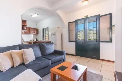a living room with a blue couch and a table at Avelino Apartment by Atlantic Holiday in Machico