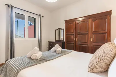 a bedroom with a large white bed and a window at Avelino Apartment by Atlantic Holiday in Machico