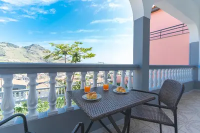 a table on a balcony with two glasses of orange juice at Avelino Apartment by Atlantic Holiday in Machico