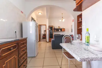 a kitchen with a white refrigerator and a table with chairs at Avelino Apartment by Atlantic Holiday in Machico