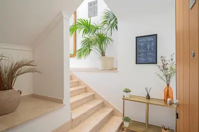 a hallway with stairs and potted plants on the walls at Casa do Castelo by An Island Apart in Funchal