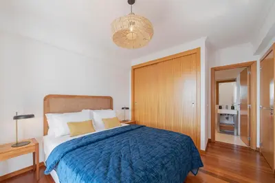 a bedroom with a large bed with a blue blanket at Casa do Castelo by An Island Apart in Funchal
