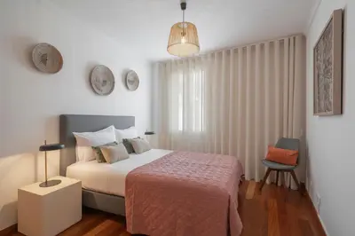 a bedroom with a bed and a lamp and a chair at Casa do Castelo by An Island Apart in Funchal