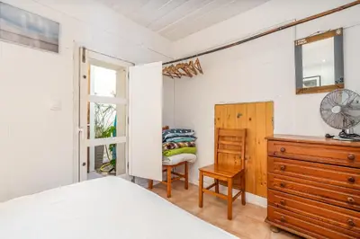 a bedroom with a bed and a dresser and a chair at Casa da Praia 2 in Budens