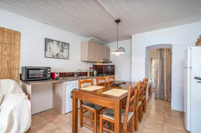 a kitchen and dining room with a table and chairs at Casa da Praia 2 in Budens