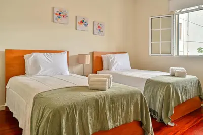 two beds sitting next to each other in a bedroom at Nidia’s Place, a Home in Madeira in Machico