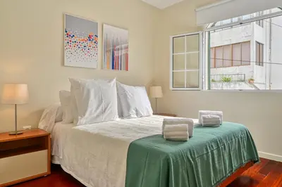 a bedroom with a bed with a green blanket on it at Nidia’s Place, a Home in Madeira in Machico