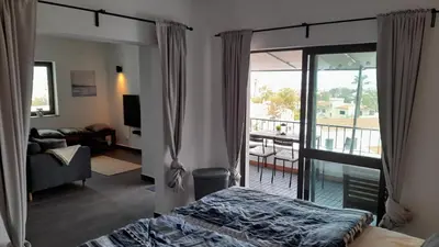 a bedroom with a bed and a living room with a balcony at 202 Lagood in Lagos