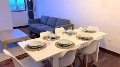 a dining room with a table with chairs and a couch at Madeira, 3 bedroom apartment with ocean views in Funchal in Funchal