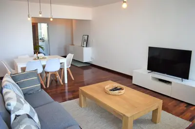 a living room with a couch and a tv and a table at Madeira, 3 bedroom apartment with ocean views in Funchal in Funchal