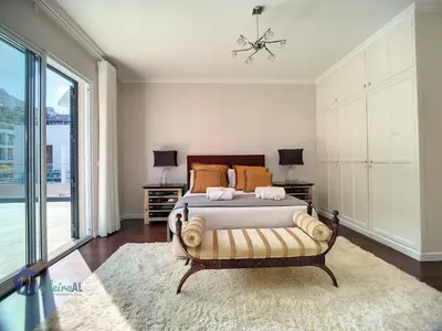 a bedroom with a bed and a large window at PEARLS BEACH VILLA in Porto Moniz