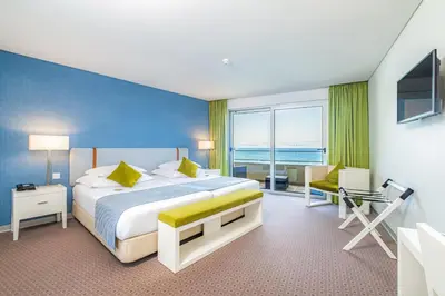 a bedroom with a large bed and a large window at Aqua Natura Madeira in Porto Moniz