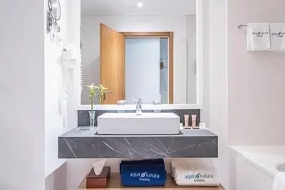 a bathroom with a sink and a mirror at Aqua Natura Madeira in Porto Moniz