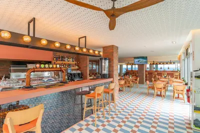 a restaurant with a bar and tables and chairs at Aqua Natura Madeira in Porto Moniz