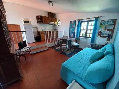 a living room with a blue couch and a kitchen at Cool Villas T2 in Sagres