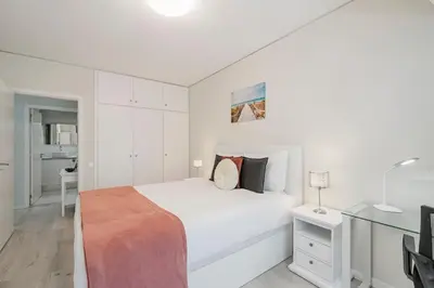 a white bedroom with a bed and a desk at Varandas do Lido I by An Island Apart in Funchal
