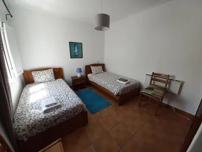 a small room with two beds and a chair at Cool Villas T4 in Sagres