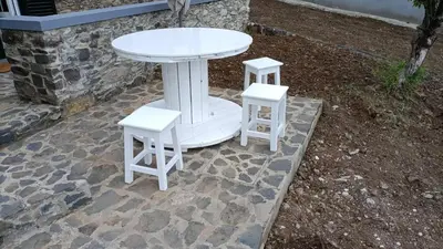 a white table and two stools on a patio at Casa do Avô in Ponta do Sol