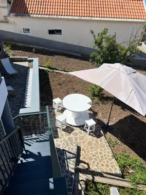 a white table and an umbrella on a patio at Casa do Avô in Ponta do Sol