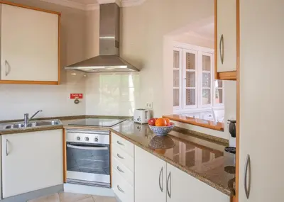 a kitchen with white cabinets and a sink at Villa Acacias 18, Brisa do Mar in Luz