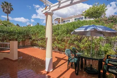a patio with an umbrella and a table with an umbrella at Villa Acacias 18, Brisa do Mar in Luz