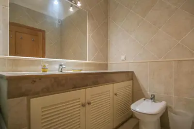 a bathroom with a sink and a toilet and a mirror at Villa Acacias 18, Brisa do Mar in Luz