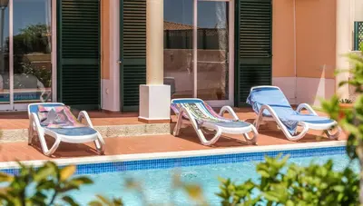 three lounge chairs sitting next to a swimming pool at Villa Acacias 18, Brisa do Mar in Luz