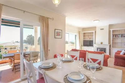 a dining room with a table and a living room at Villa Acacias 18, Brisa do Mar in Luz
