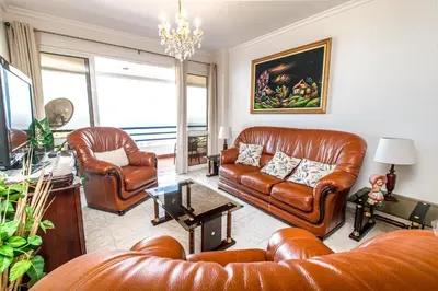 a living room with leather furniture and a chandelier at Sea and sunset view apartment in Funchal in Funchal