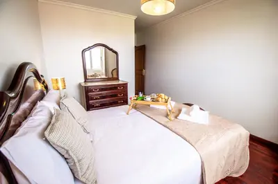 a bedroom with a bed with a dresser and a mirror at Sea and sunset view apartment in Funchal in Funchal