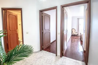 a hallway with two open doors and a chair at Sea and sunset view apartment in Funchal in Funchal