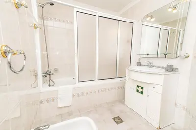 a white bathroom with a sink and a shower at Sea and sunset view apartment in Funchal in Funchal