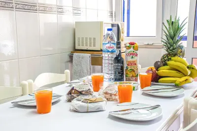 a table with a bunch of food and orange juice at Sea and sunset view apartment in Funchal in Funchal