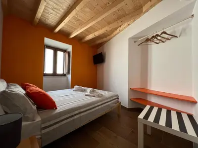 a small bedroom with orange walls and a bed at Casa Arenga in Almádena