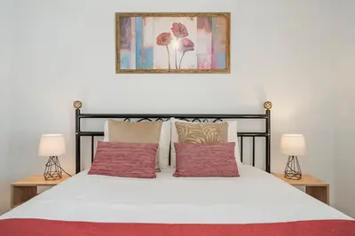 a bedroom with a white bed with two lamps at Terrace Vila II by An Island Apart in Santa Cruz